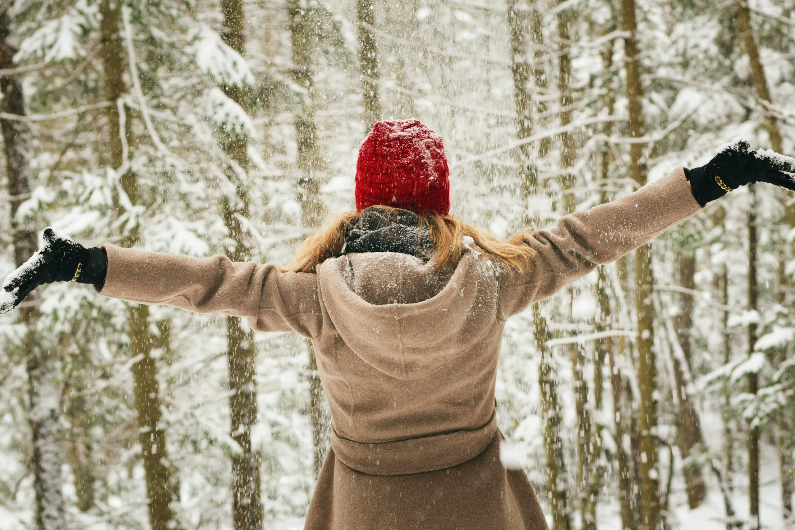 Eine Frau hebt ihre Arme im Schneetreiben