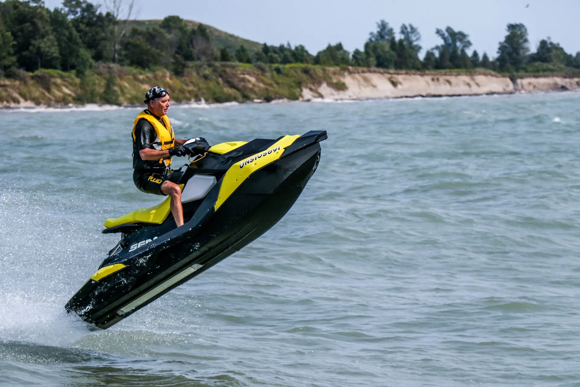 Ein Mann springt mit einem Sea Doo Jet-Ski über das Wasser