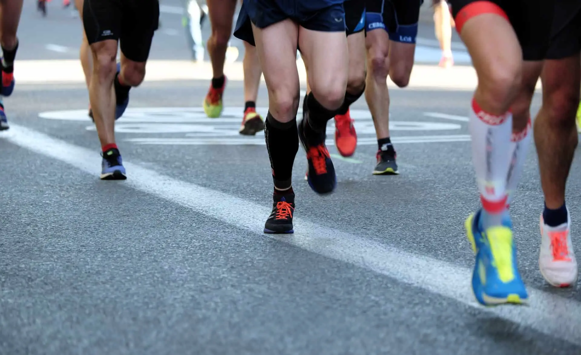 Ansicht der Beine von mehreren Läufern bei einem Stadtlauf